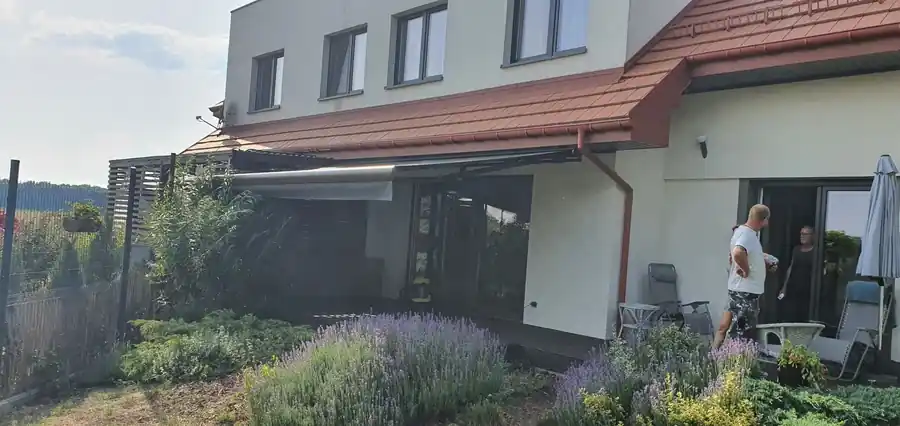 Markiza tarasowa przy domu z ogrodem